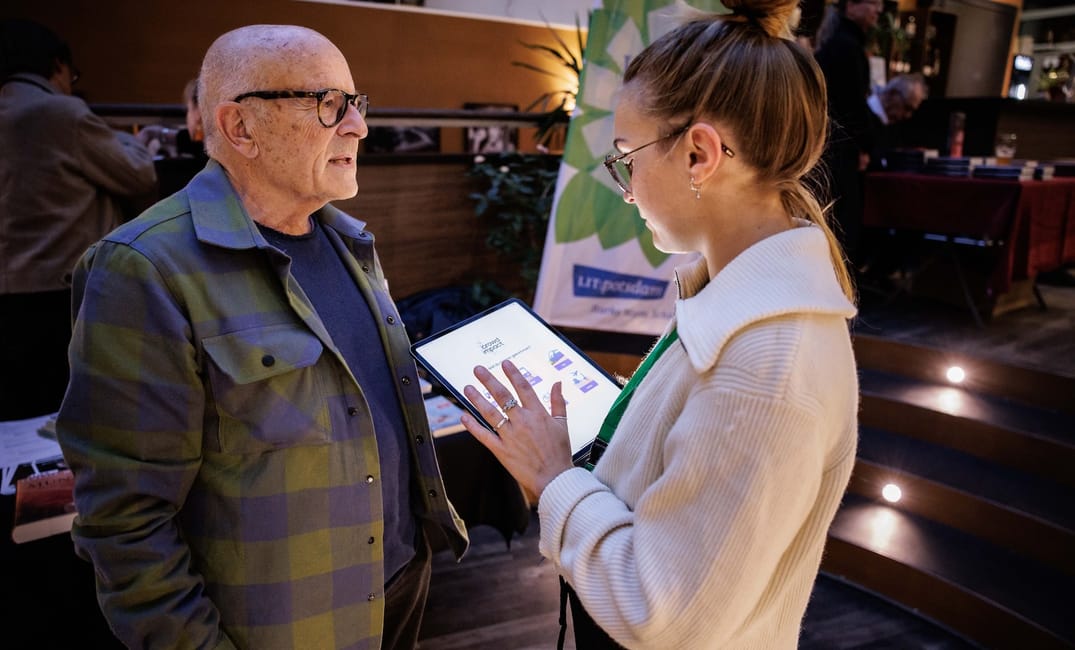 Person führt mit einem iPad eine Mobilitätsbefragung mit der Crowd Impact Software bei Veranstaltungsbesuchenden durch.